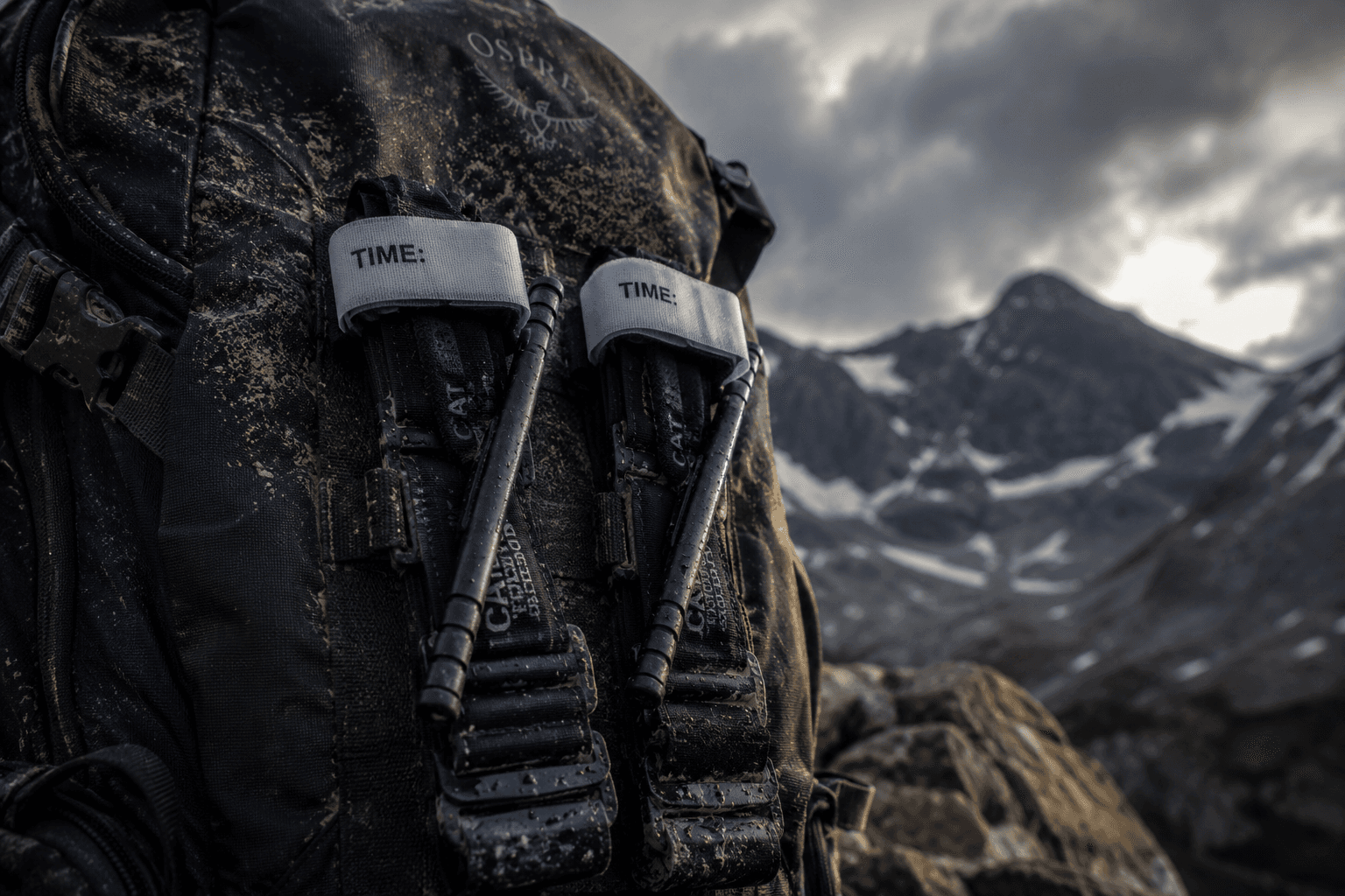 Two black Combat Application Tourniquets (CAT) attached to the outside of a wilderness backpack.